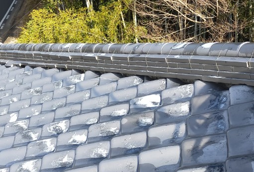 台風後に瓦屋根の棟が歪んでいる写真