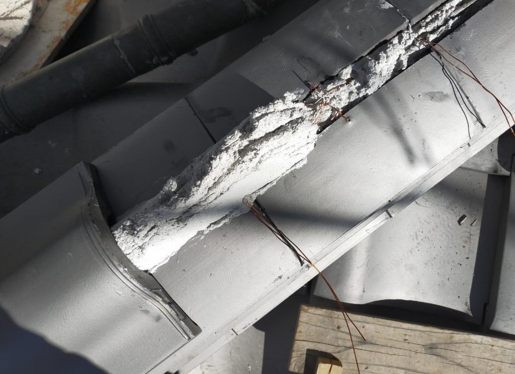 瓦屋根の棟積み直し工事を行っている作業中の様子