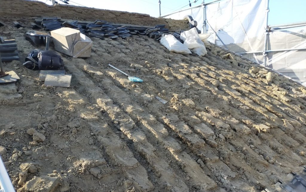 瓦屋根の葺き替えで行われる既存瓦の撤去作業の様子