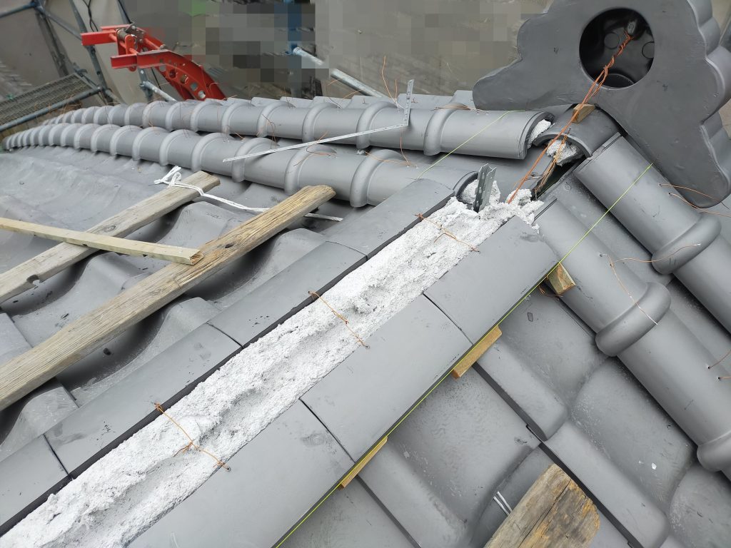 棟部分を整え、瓦を固定している施工中の様子