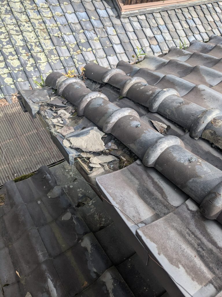 裏面屋根の中でも劣化が集中していたケラバ周辺の瓦の状態を確認している様子