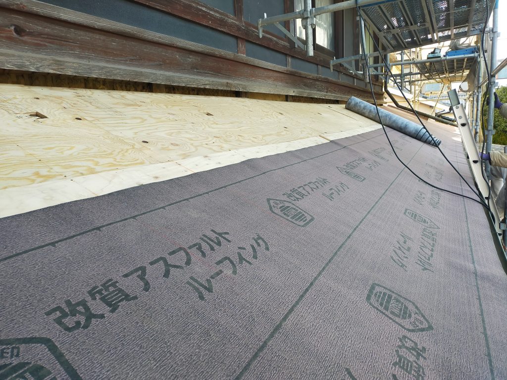 下屋根に防水性能を確保するためルーフィングを丁寧に施工している工程