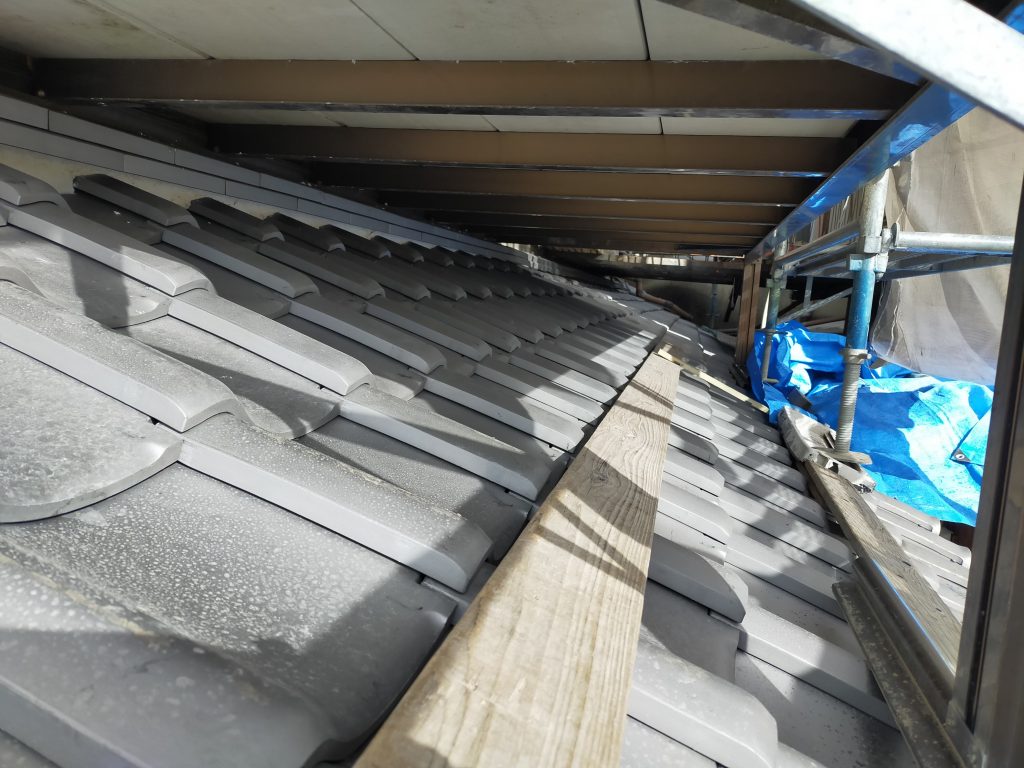 下屋根の瓦を一枚ずつ納まりを確認しながら葺き上げている施工中の様子２