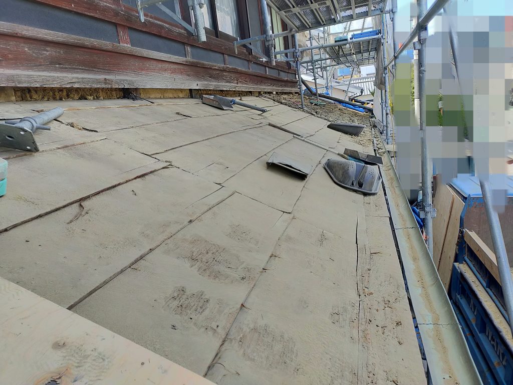 下屋根の瓦と葺き土を撤去し、下地の状態を確認している作業中の様子