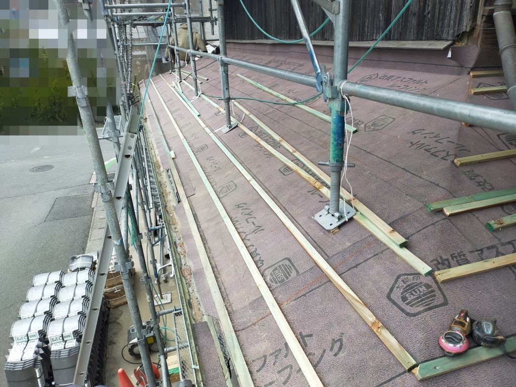 瓦を正しく固定するため、下屋根に桟木を施工している様子