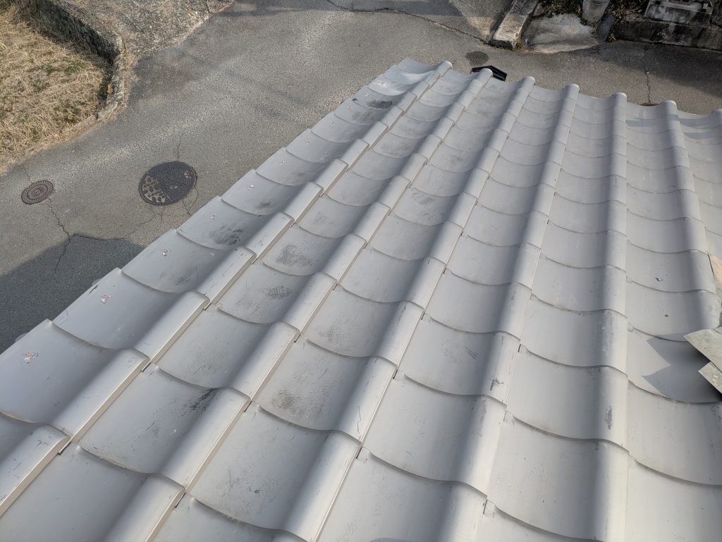 割れて使えない瓦を交換し既存瓦を復旧している施工中写真